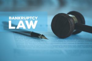 Gavel and fountain pen on top of New York Chapter 7 bankruptcy documents. 