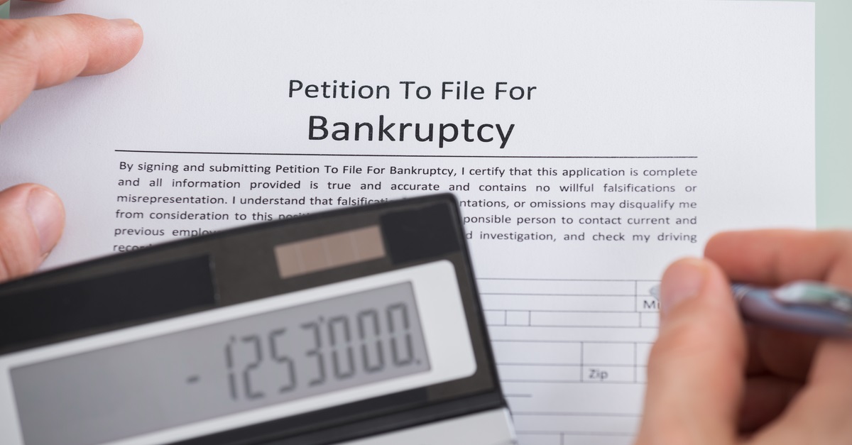 Businessman writing a petition to file for bankruptcy.