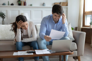 Anxious young couple feel stressed managing household finances documents.