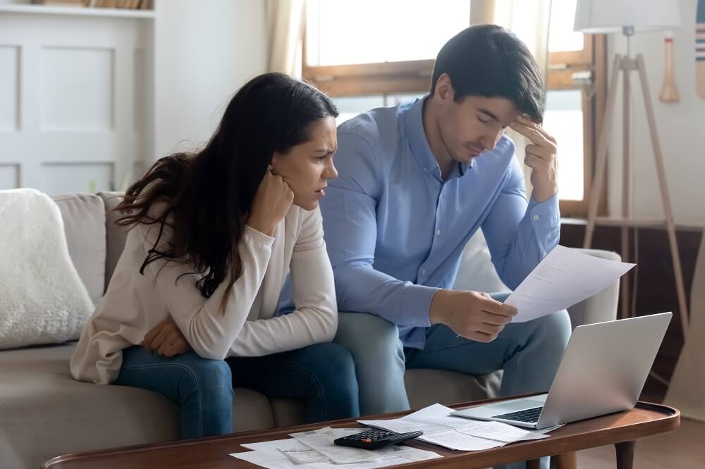 Sad couple thinking about their unpaid debts planning to file for bankruptcy.